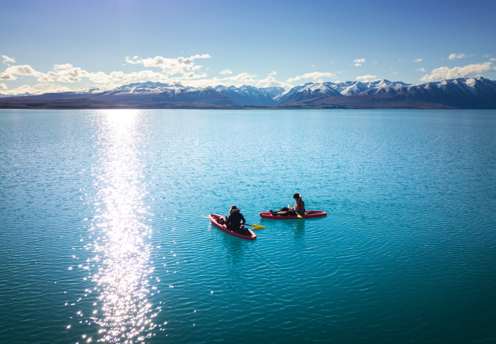 Kayaking Lake Tekapo, turquoise opaque waters with snowy mountains in background