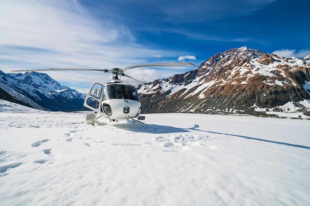 Helicopter landing on snowy mountain in Mt Cook National Park